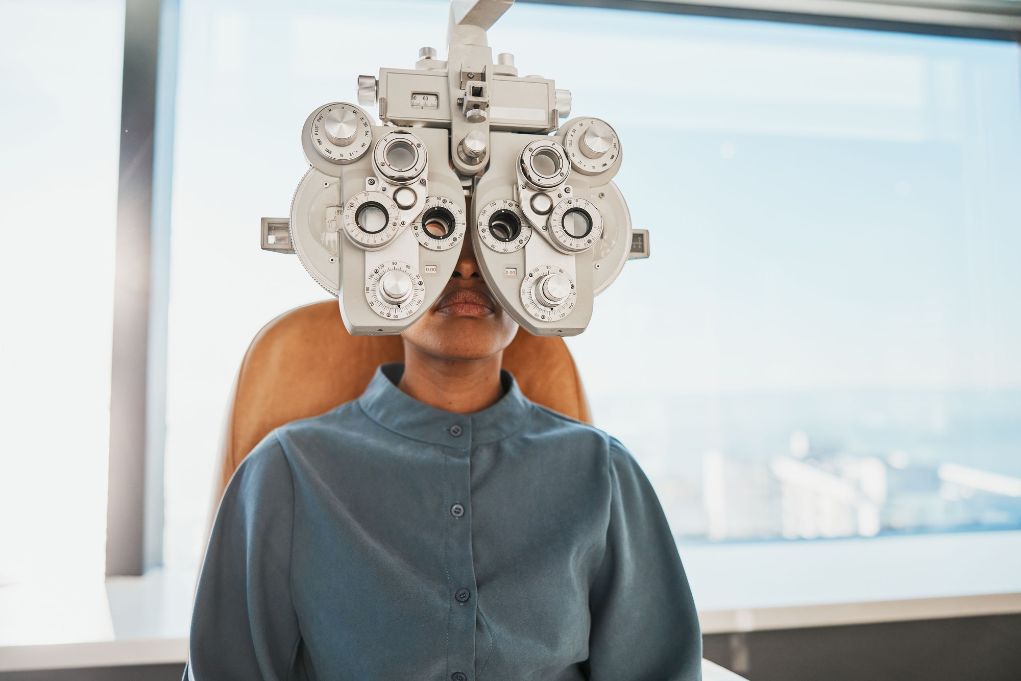 A patient during a comprehensive eye exam using a phoropter