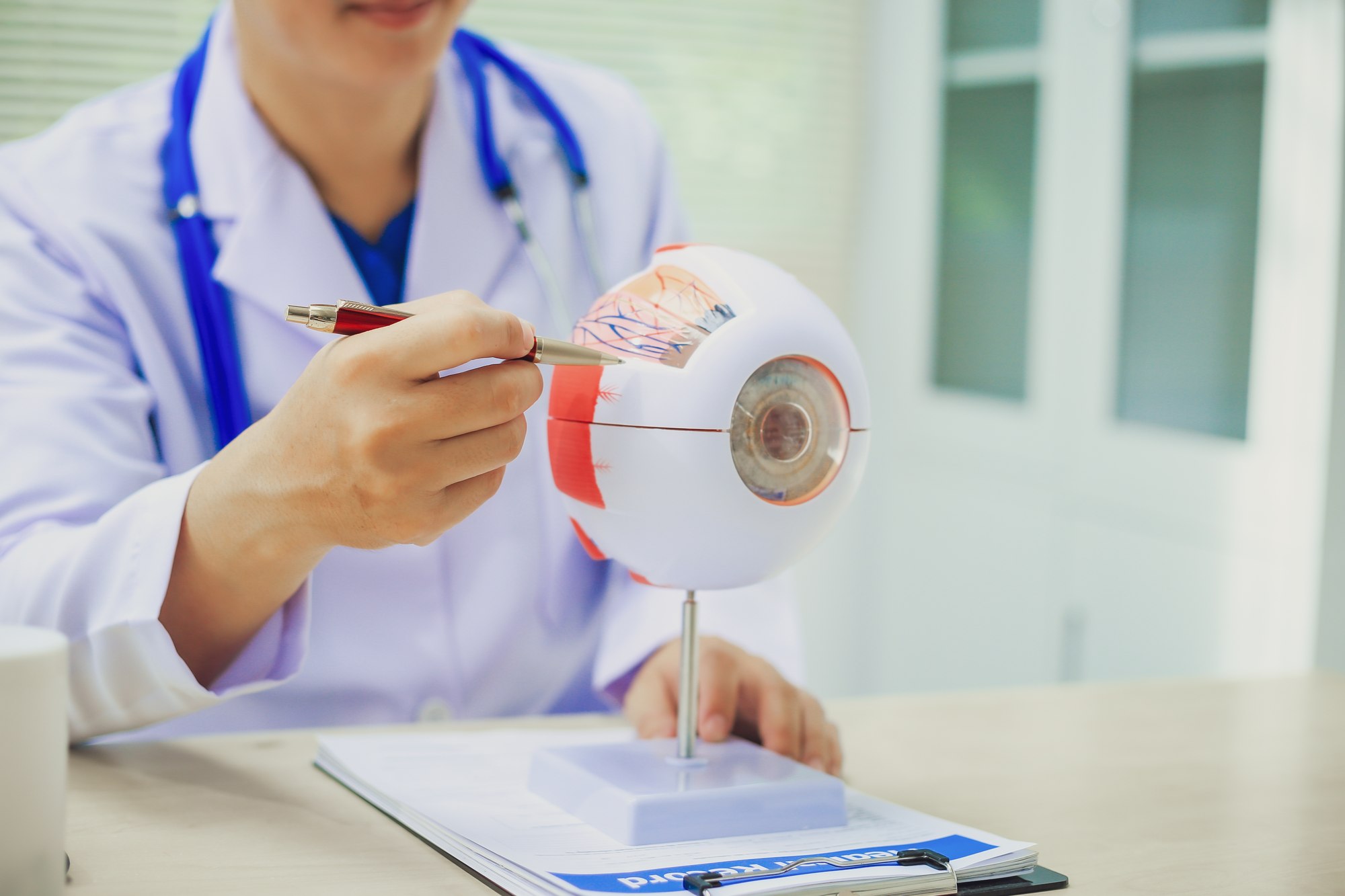 A doctor explaining diabetic eye disease using an eye model