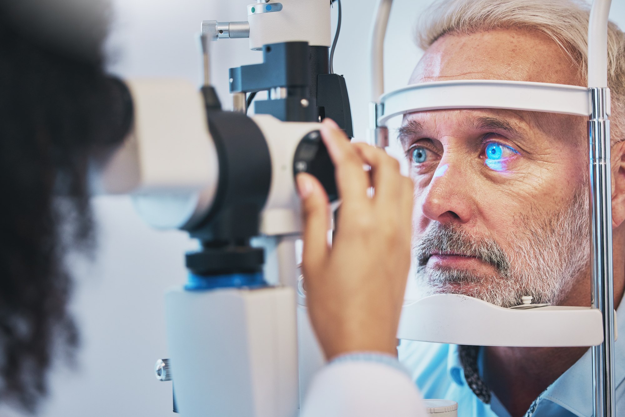 A patient undergoing a slit lamp exam for glaucoma testing