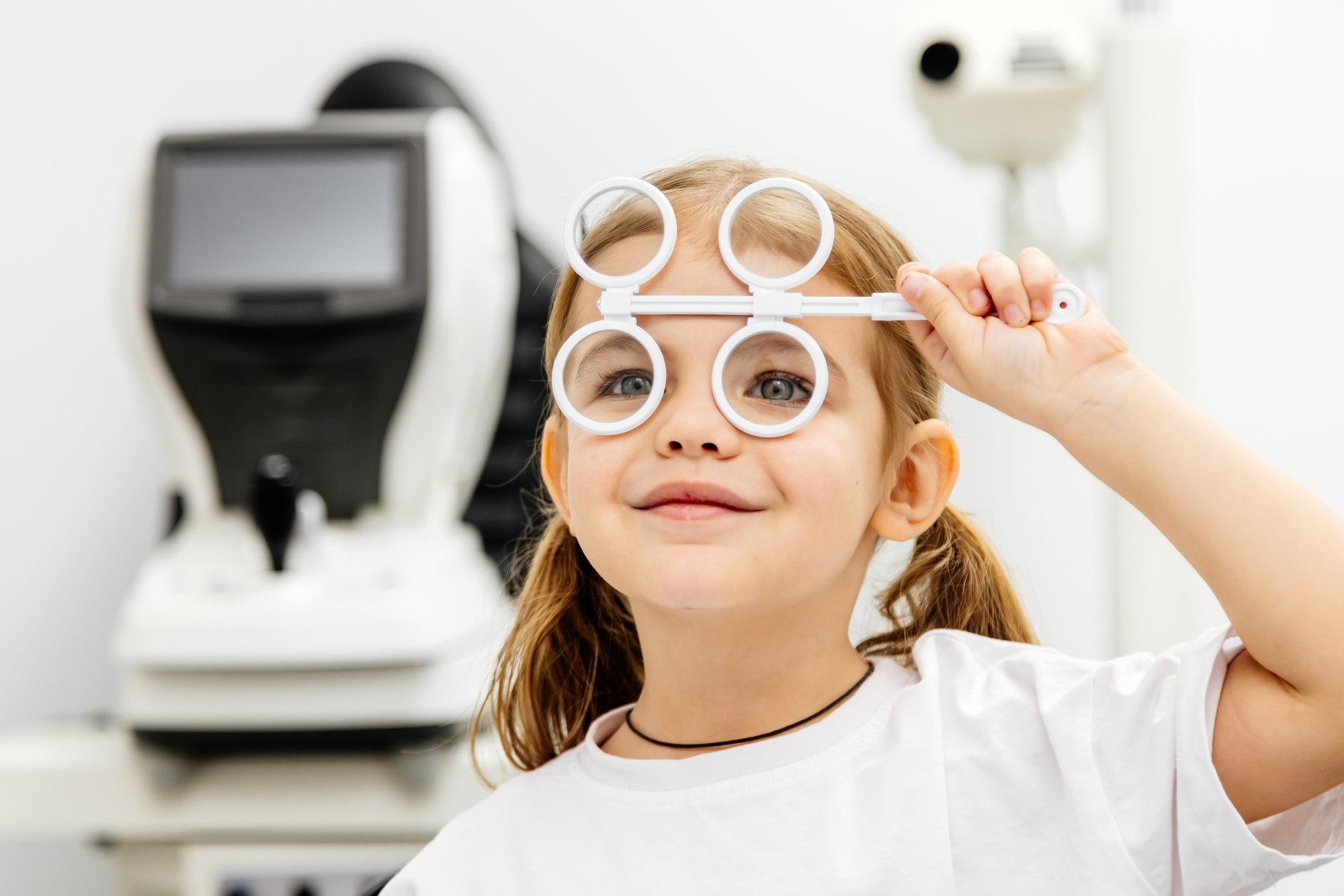 A young girl smiling during a pediatric eye exam